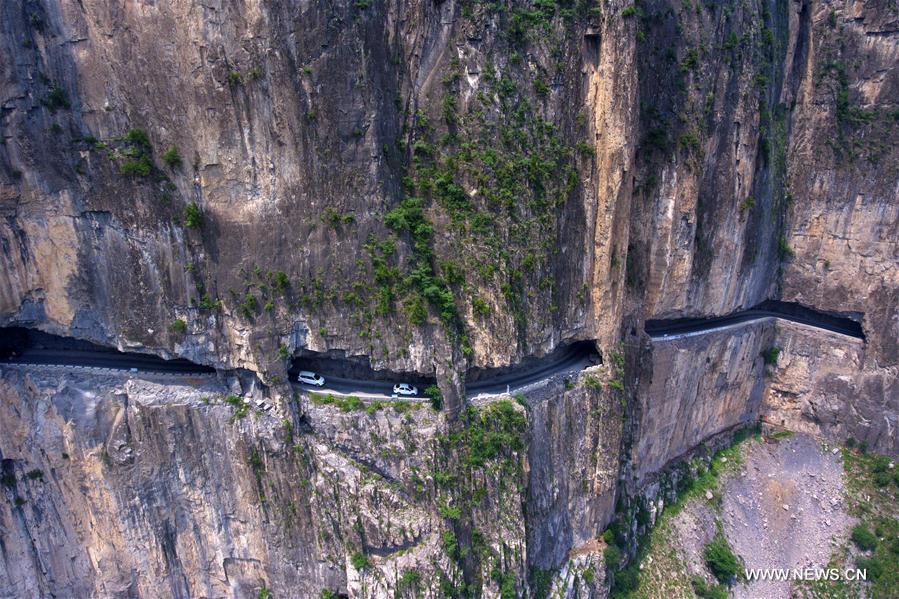 الصورة: سيارات تسير على طريق بين منحدرات في قرية شنلونغوان شمالي الصين