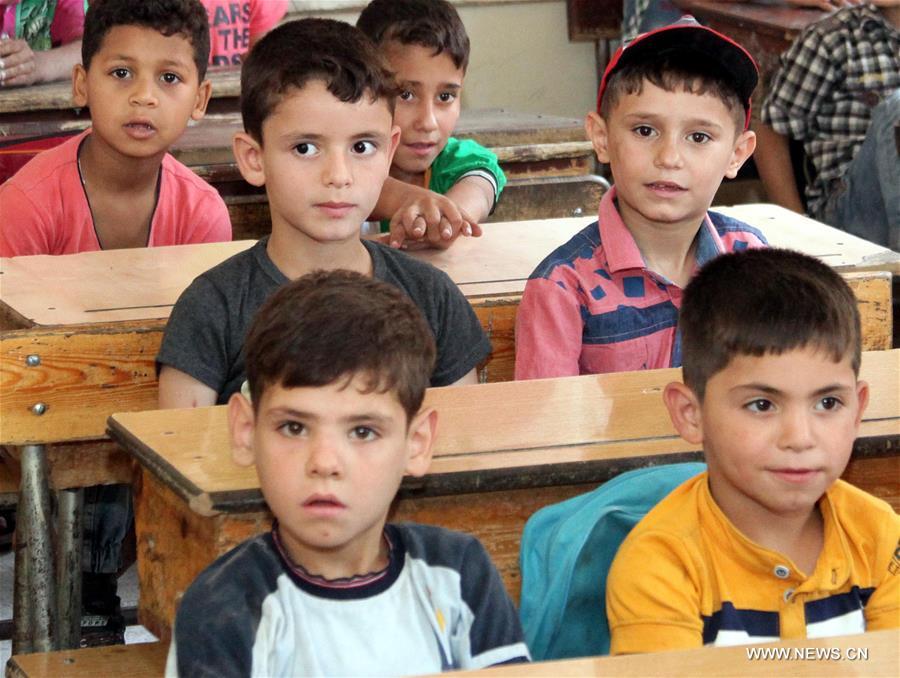 الصورة: أطفال سوريون يجلسون في فصل في مدرسة بالغوطة الشرقية 