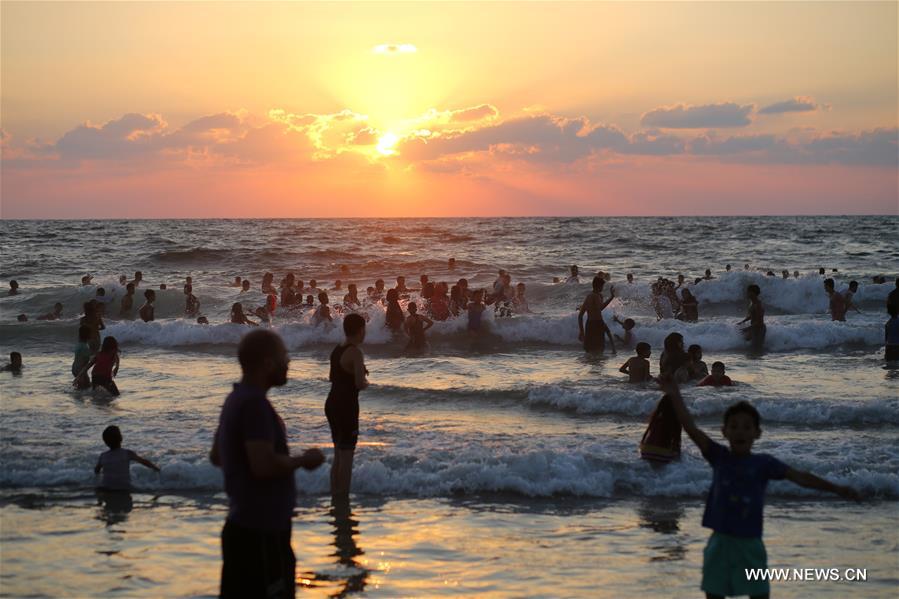 الصورة: فلسطينيون يستمتعون بعطلتهم الصيفية على شاطئ بمدينة غزة 