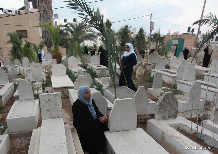 الصورة : زيارة القبور خلال عيد الأضحى في نابلس بالضفة الغربية 