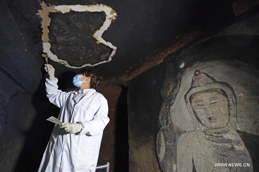 الصورة: ترميم اللوحات الجدارية فى كهوف شيويميشان بشمال غربي الصين