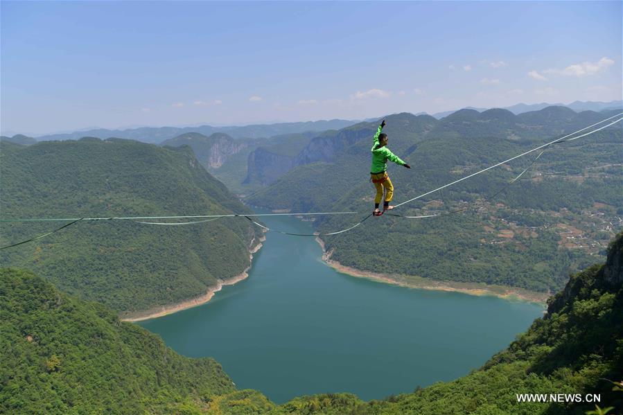 الصورة: شاب يمشي على شريط مسطح على ارتفاع شاهق في الصين