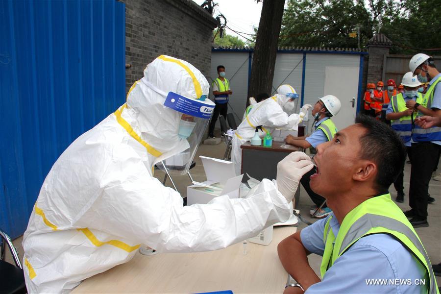 الصورة: عمال بناء يخضعون لاختبارات الحمض النووي للكشف عن فيروس كورونا الجديد   