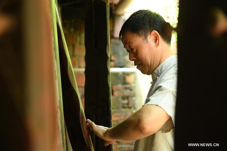 الصورة: صانع لآلة "قو تشين" الموسيقية الصينية التقليدية في شرقي الصين