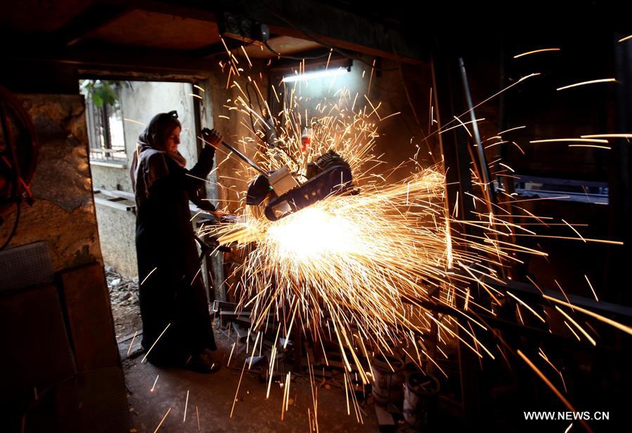 الصورة: فلسطينية تشارك زوجها مهنة الحدادة في الضفة الغربية