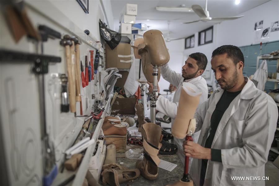 الصورة: فلسطينيون يعملون في مركز الأطراف الصناعية بغزة