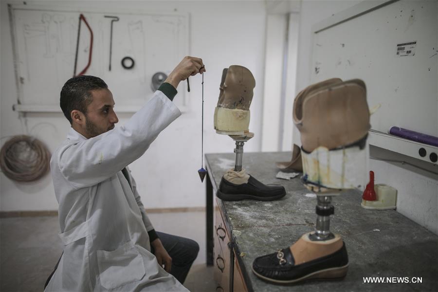 الصورة: فلسطينيون يعملون في مركز الأطراف الصناعية بغزة