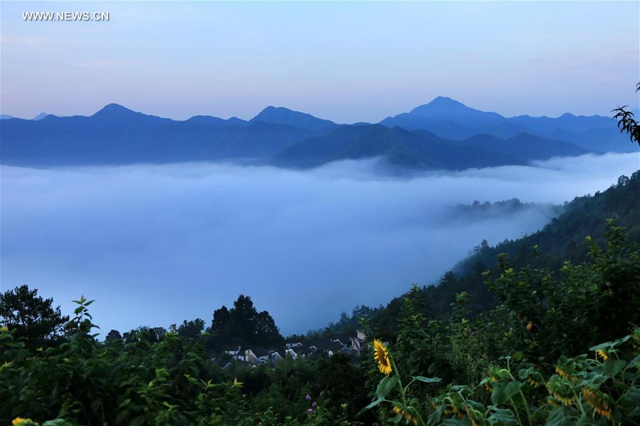 الصورة: قرية قديمة وسط الغيوم والسحب في شرقي الصين