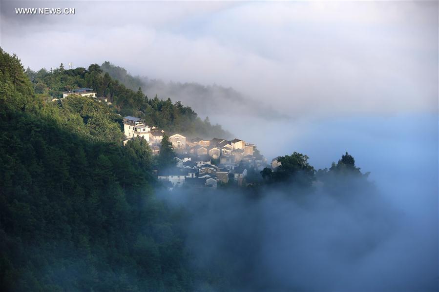 الصورة: قرية قديمة وسط الغيوم والسحب في شرقي الصين