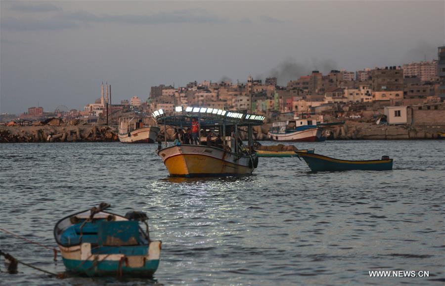 الصورة: صيادون فلسطينيون يركبون قواربهم وسط ميناء غزة 