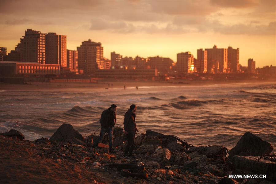 الصورة: فلسطينيون يستمتعون بغروب الشمس على شاطئ غزة