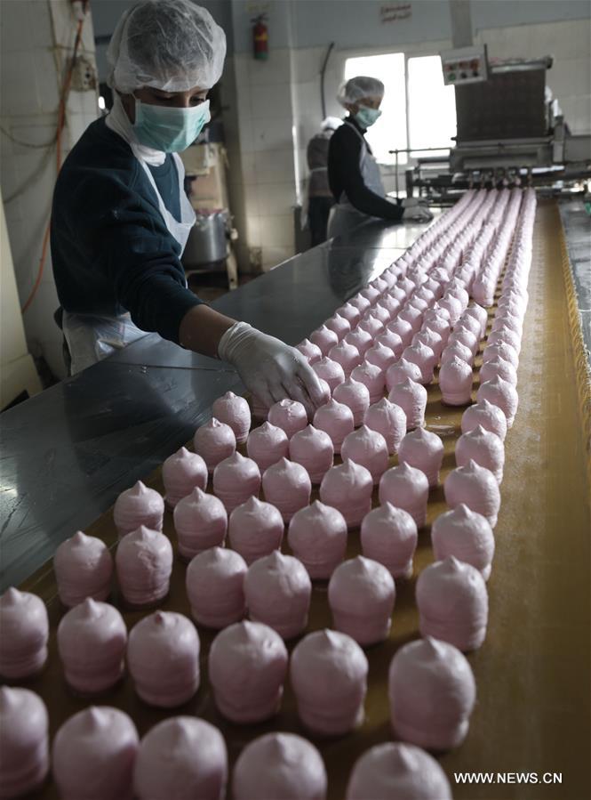 الصورة: فلسطينيون يصنعون حلوى "رأس العبد" في الضفة الغربية