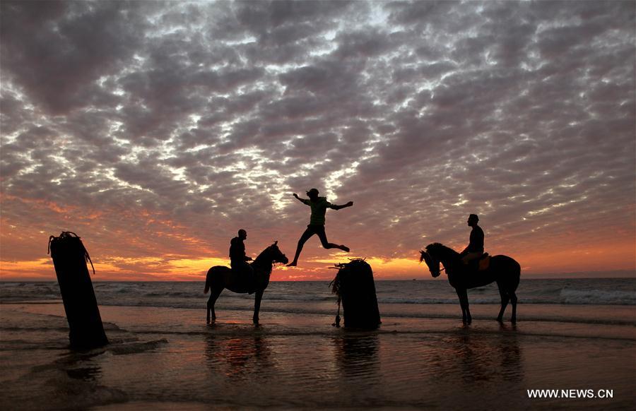 الصورة: فلسطينيون يستمتعون بغروب الشمس على شاطئ غزة
