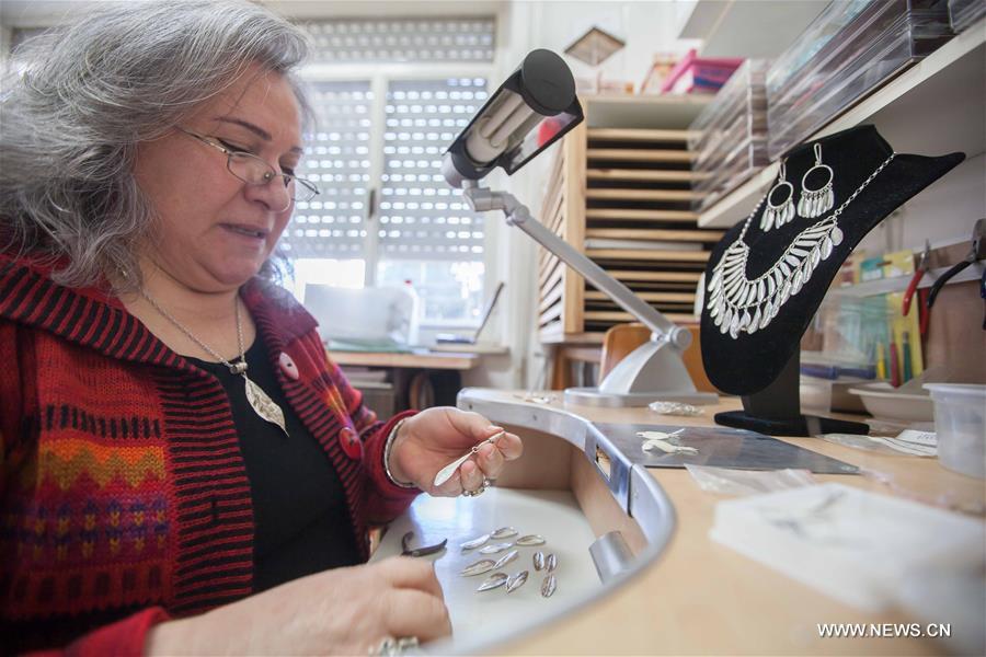 الصورة: فلسطينية تصنع المجوهرات الفضية على شكل أوراق الزيتون في الضفة الغربية 