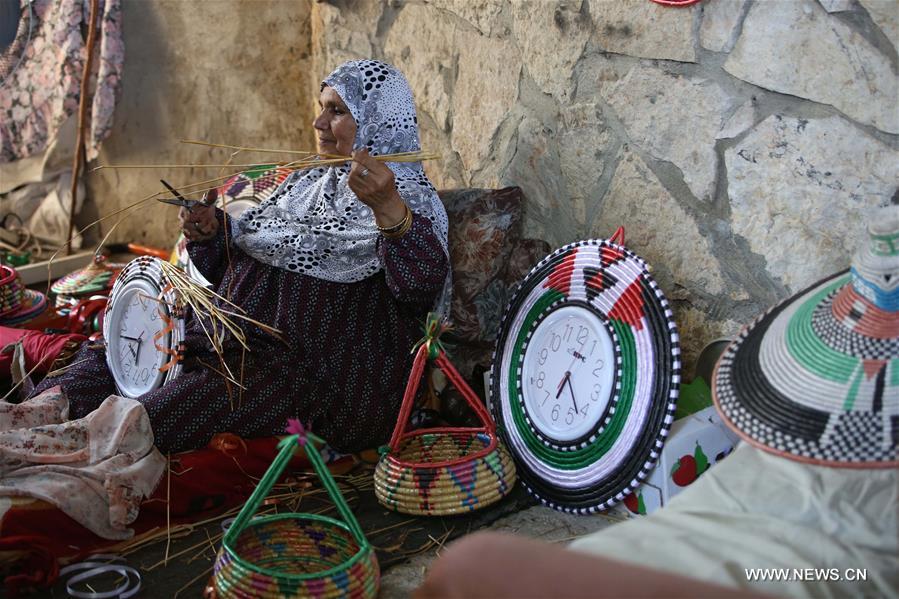الصورة: فلسطينية تصنع صواني القش في الضفة الغربية