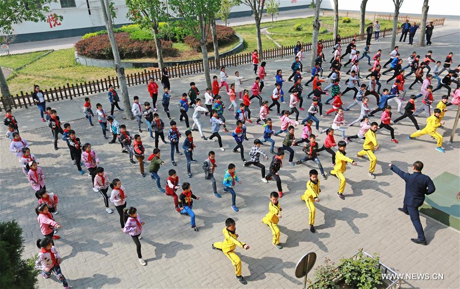 الصورة:تلاميذ يتعلمون فنون رياضة "ووشو" في مدرسة ابتدائية بمدينة شيجياتشوانغ