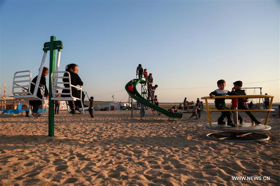 الصورة: أطفال فلسطينيون يلعبون قرب الحدود بين إسرائيل وغزة