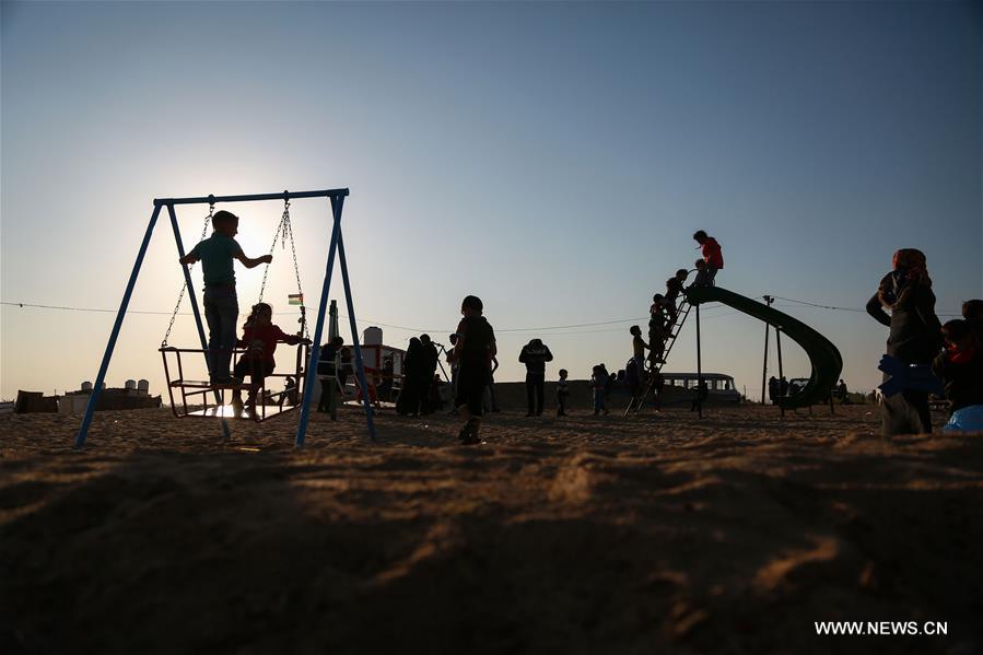 الصورة: أطفال فلسطينيون يلعبون قرب الحدود بين إسرائيل وغزة
