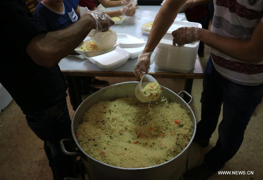 الصورة: فلسطينيون يجهّزون وجبات إفطار مجانية في الضفة الغربية بمناسبة رمضان