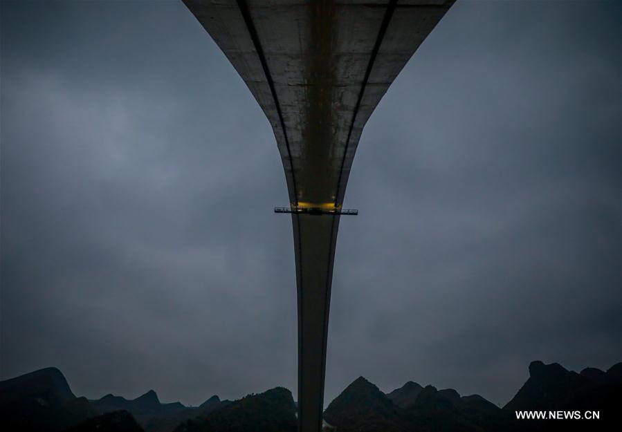 الصورة : عامل معلق على جسر للسكة الحديدية الفائقة السرعة