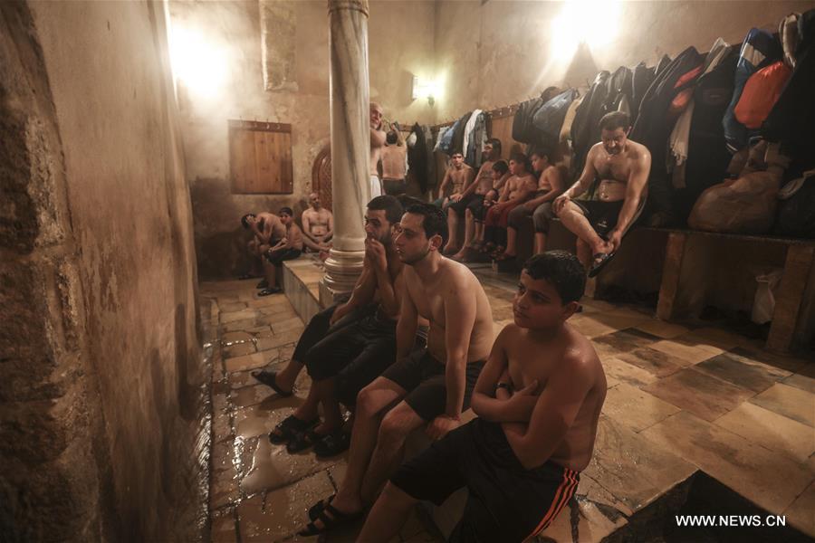 الصورة: فلسطينيون يستمتعون بوقتهم داخل "حمام السمرة" التاريخي في مدينة غزة 