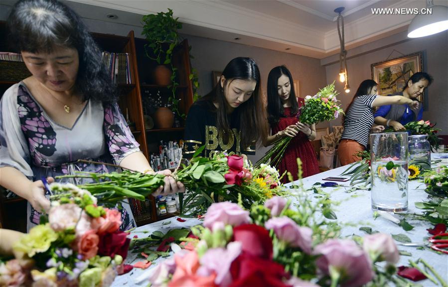 الصورة: نساء يدرسن فن ترتيب الزهور