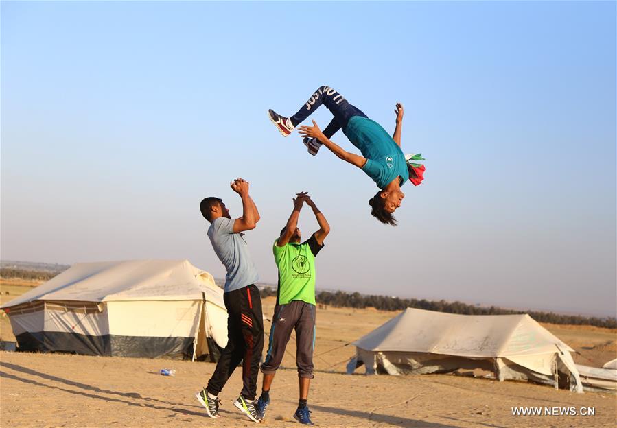 الصورة: شبان فلسطينيون يمارسون رياضة الباركور على الحدود مع إسرائيل جنوب قطاع غزة