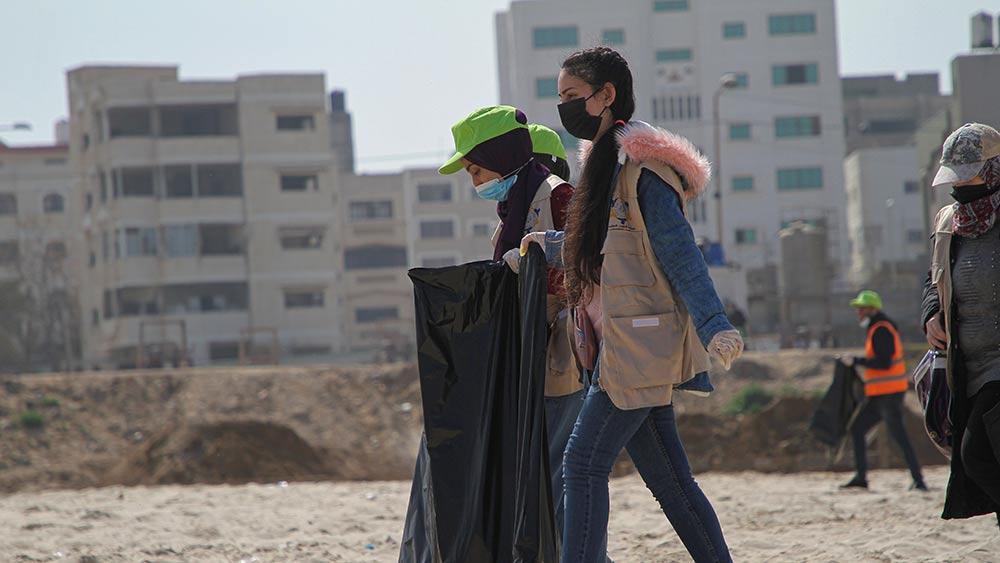 متطوعون فلسطينيون ينظفون شاطئ في مدينة غزة