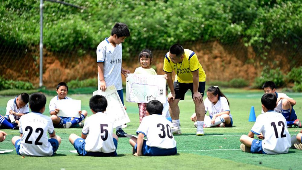 أطفال يحلمون بلعب كرة القدم في قرية بجنوبي الصين