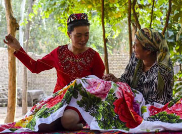 أختان ويغوريتان تعرضان سحر ثقافة التطريز في بكين