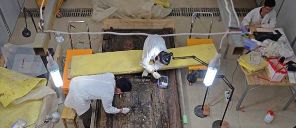 آثاريون صينيون ينظفون تابوت داخل مقبرة تعود إلى ألفي سنة بشرقي الصين