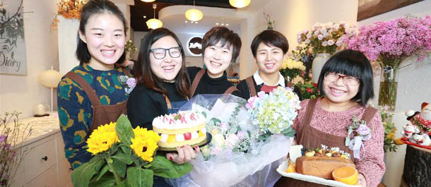 فتيات يبعن الزهور مع أنواع الكعك اللذيذ في شمالي الصين