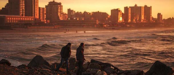 فلسطينيون يستمتعون بغروب الشمس على شاطئ غزة