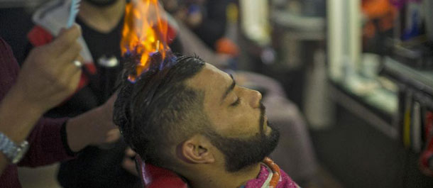حلاق فلسطيني يستخدم النار في حلاقة الشعر في مخيم رفح في قطاع غزة