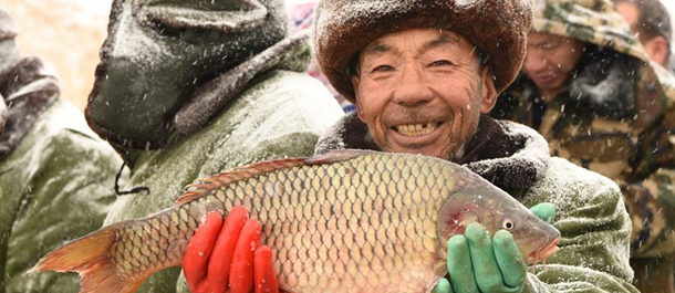 صيد الأسماك من على سطح بحيرة متجمدة بشمالي الصين