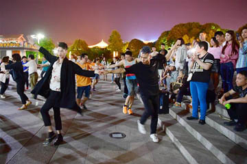 الشباب يقومون برقص الساحة الصيني في الليلة بمدينة شيان