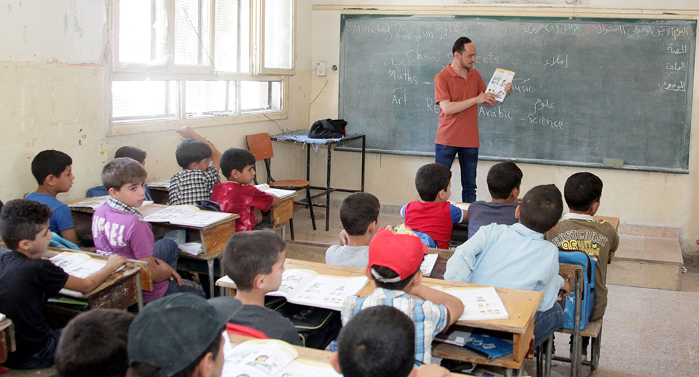 أطفال سوريون يتلقون درسا في مدرسة بالغوطة الشرقية