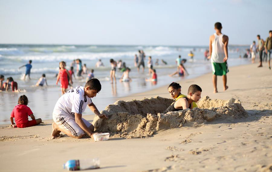 فلسطينيون يستمتعون بعطلتهم الصيفية على شاطئ بمدينة غزة