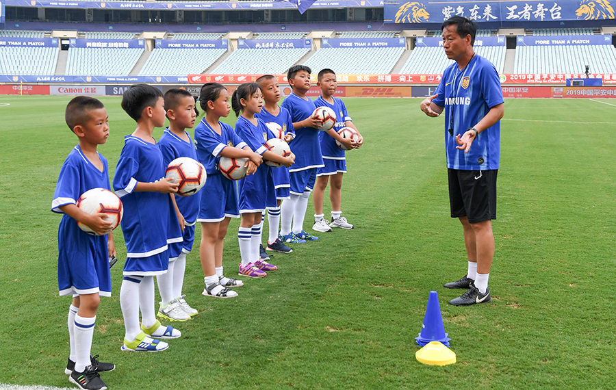 الأطفال يدرسون المهارات الأساسية في كرة القدم لقضاء العطلة الصيفية