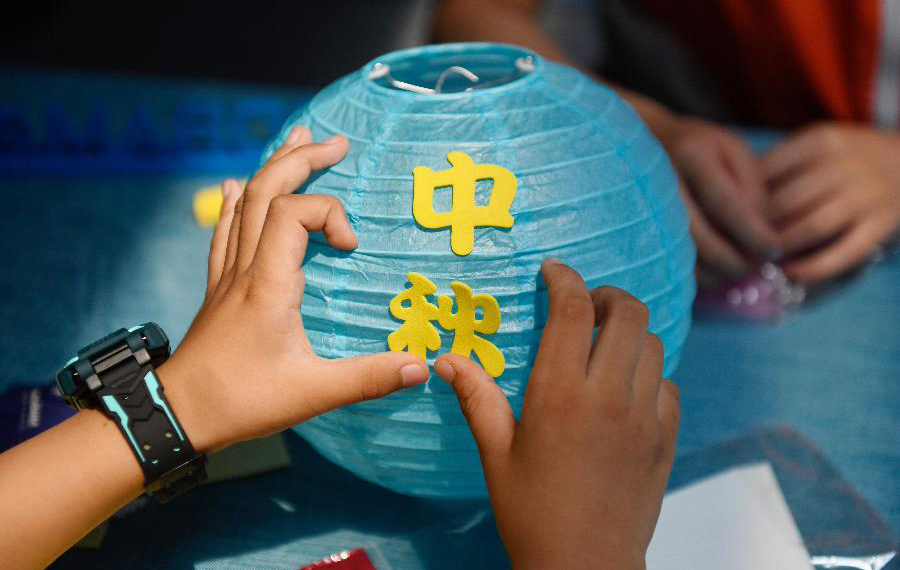 الأطفال تصنعون أعمالا يدوية وكعكة القمر للاحتفال بعيد منتصف الخريف في شرقي الصين