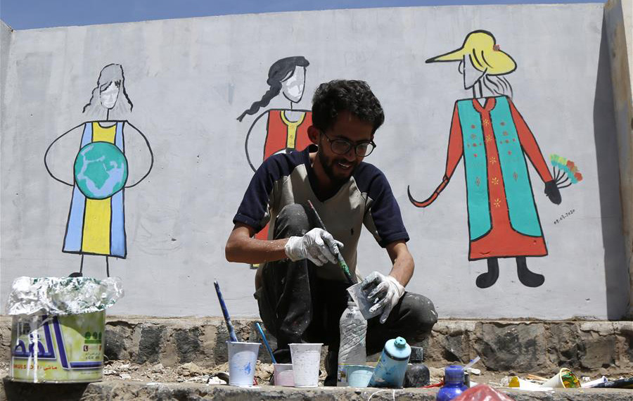 فنان يمني يرسم على الحائط للاحتفال باليوم العالمي للمرأة في صنعاء