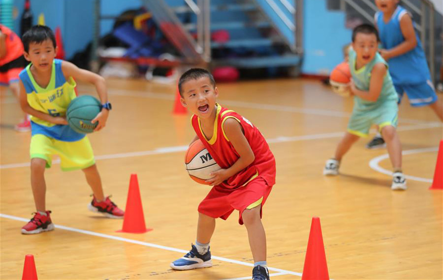 طلاب صينيون يشاركون في تدريبات رياضة الكرة خلال العطلة الصيفية لتقوية أجسامهم