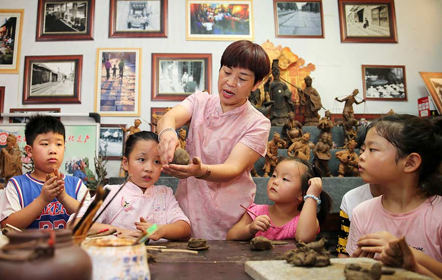 الأطفال الصينيون تجربون صنع نحت الطين خلال الإجازة الصيفية بمقاطعة أنهوي