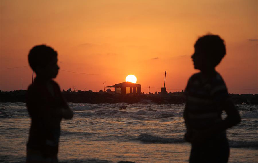 التمتع بوقت الفراغ عند غروب الشمس على شاطئ مدينة غزة