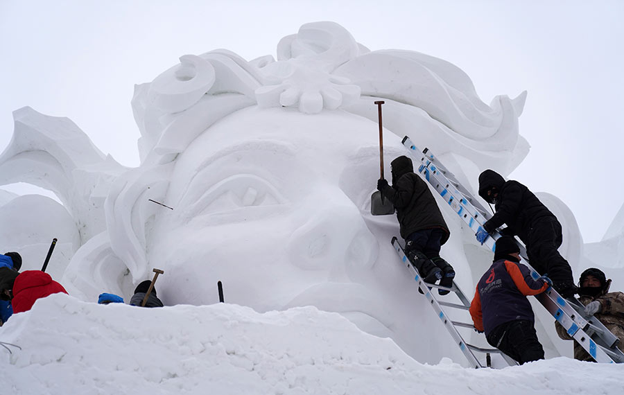 نحاتو الثلج يشغلون في صناعة الأعمال الفنية في حديقة "معرض المنحوتات الثلجية" بمدينة هاربين بشمال شرق الصين