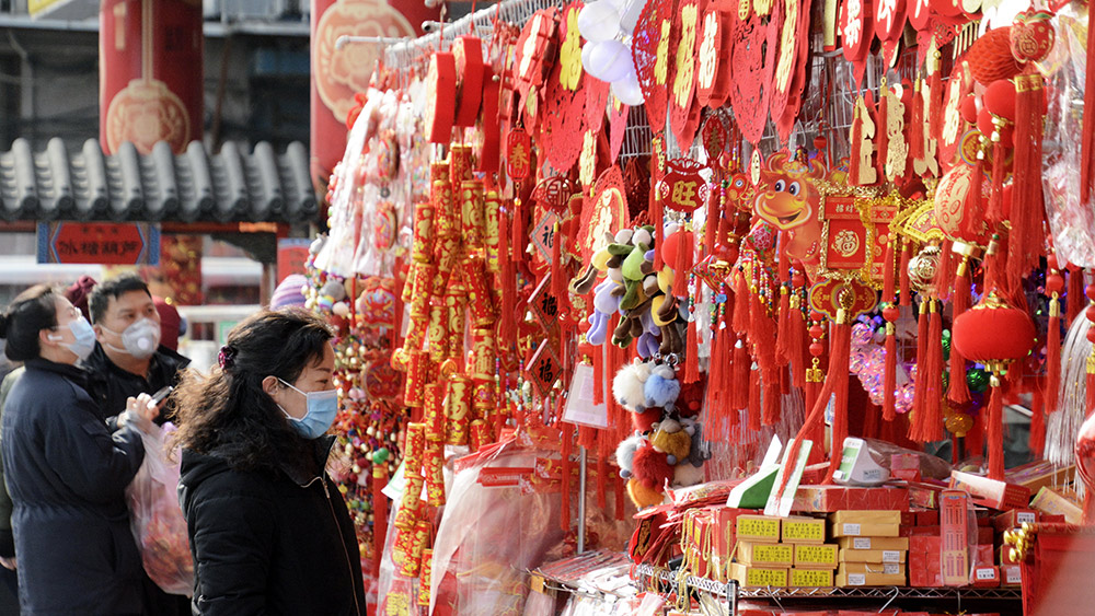 الناس يشترون الزينات في بكين لاستقبال عيد الربيع