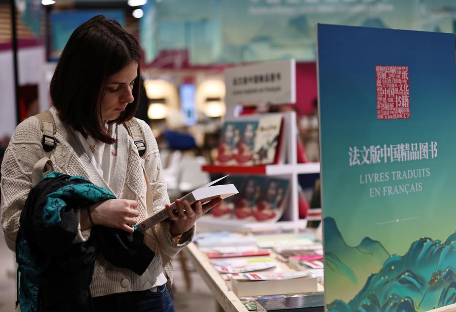 امرأة تقرأ كتابا صينيا خلال مهرجان باريس للكتاب 2024 في باريس، فرنسا، في 12 أبريل 2024. (شينخوا)
